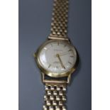 A gentleman's 18ct gold manual wind wrist watch, retailed by J.W. Benson, on a 9ct gold bracelet,