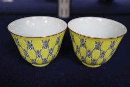 A pair of Chinese yellow glazed tea bowls, height 5cm