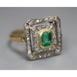 A modern 18ct gold, emerald and diamond chip cluster tablet ring, size O, gross 4.9 grams, (stone