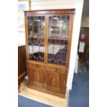 A George III style mahogany bookcase cupboard, width 106cm, depth 33cm, height 200cm