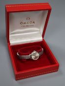 A lady's stainless steel Omega manual wind wrist watch, on associated flexible strap, case