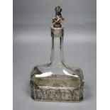 A late 19th/early 20th century German Hanau white metal mounted glass decanter, with figural