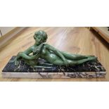 An Art Deco green patinated bronze figure of a reclining lady with a dog, on marble plinth, signed L