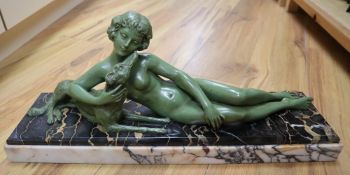 An Art Deco green patinated bronze figure of a reclining lady with a dog, on marble plinth, signed L