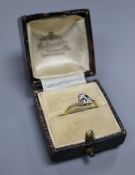 An Art Deco 18ct and plat, two stone diamond crossover ring with stylised shoulders, size M, gross