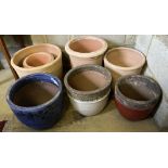 Seven glazed earthenware and terracotta garden pots, largest 37cm diameter