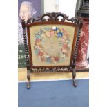 A Victorian rosewood firescreen with armorial tapestry banner, width 75cm, height 105cm