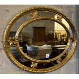 An oval gilt carved wood framed wall mirror with marginal plate, 92 x 71cm