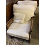 A pair of early 20th century mahogany framed bergere armchairs with caned sides, and cream brocade