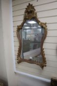 An 18th century style carved giltwood rococo wall mirror, 59 x 104cm