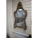 An 18th century style carved giltwood rococo wall mirror, 59 x 104cm