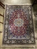 A Kashan burgundy ground rug, 152 x 109cm