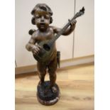 A patinated bronze statuette, cherub playing a lute, base signed, 58cm