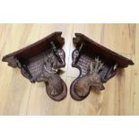 A pair of Black Forest walnut deer's head wall brackets, late 19th century, height 24cm