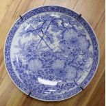 A large Chinese porcelain wall plate, painted with birds and flowering shrubs in underglaze blue