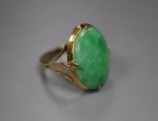 A yellow metal and oval cabochon jadeite set ring, size J, gross 4.6 grams, stone dimensions approx.