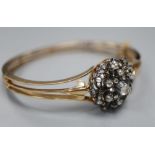 An early 20th century pierced yellow metal and diamond cluster set hinged bracelet, with safety