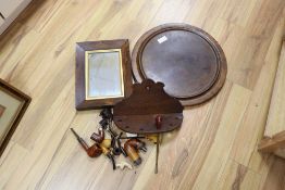 Two treen trays, a Victorian rosewood frame mirror and various smoking pipes and a rack, largest