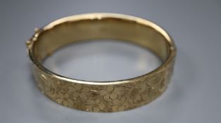 A 9ct engraved gold hollow hinged bangle, Cropp & Farr, Birmingham 1974, 20.9g.