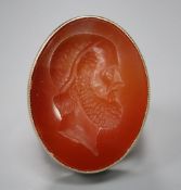 A 9ct and intaglio carnelian oval ring, carved with the head of a gentleman to dexter, size W, gross