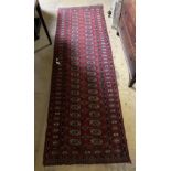 A Bokhara burgundy ground runner, 250 x 80cm