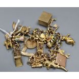 A yellow metal charm bracelet, hung with twenty seven assorted charms, including 9ct phone box, Toby