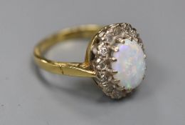 A modern 18ct gold, white opal and diamond set oval cluster ring, size J, gross 4.4 grams.CONDITION: