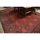 An Afghan burgundy ground carpet, 290 x 208cm