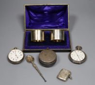 A cased pair of silver napkin rings, a silver pill box and spoon, a silver vesta case and two silver