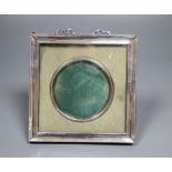 A white metal mounted photograph frame, with ribbon crest, 14cm.