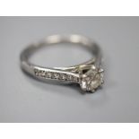 A modern platinum and single stone diamond ring, with diamond set shoulders, size N, gross 4.5