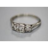 An 18ct and plat, graduated three stone diamond ring, size N/O, gross 3 grams.CONDITION: Central