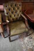 A George III style mahogany library chair, upholstered in buttoned green leather, width 58cm