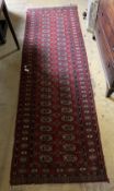 A Bokhara burgundy ground runner, 248 x 59cm