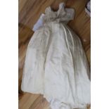 A late 1940's / early 1950's off white embroidered wedding dress and a pair of satin shoes