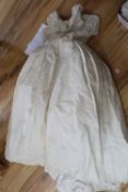 A late 1940's / early 1950's off white embroidered wedding dress and a pair of satin shoes