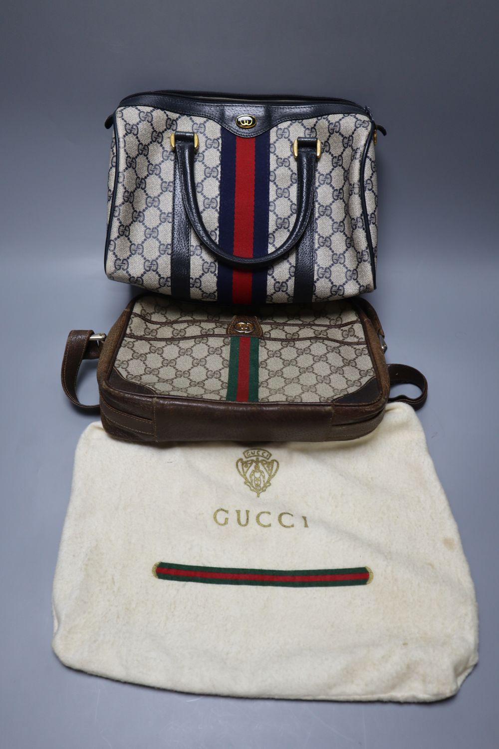 A Gucci handbag, in red holder, and one other Gucci bag