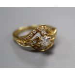 An 18ct yellow gold and diamond ring of scroll design, size O, gross 6 grams.