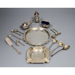 A group of small silverware including small waiter, three condiments, ashtray and minor flatware.