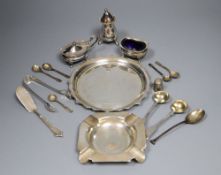 A group of small silverware including small waiter, three condiments, ashtray and minor flatware.