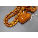 Four assorted amber bead necklaces (1 a.f.) and an amber boulder pendant, gross weight 82 grams.