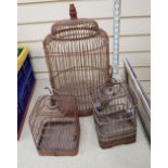 Three vintage Spanish birdcages, made of wood and metal, one with porcelain feeder pots.
