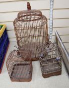 Three vintage Spanish birdcages, made of wood and metal, one with porcelain feeder pots.