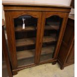 A late Victorian walnut two door glazed bookcase, width 102cm, depth 28cm, height 128cm