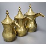 A graduated set of three Arab brass coffee pots (Dallah), tallest 29cm