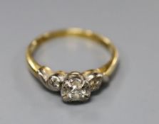 A three-stone diamond ring illusion-set in 18ct gold and platinum, size M, gross 2.9 grams.