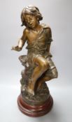 After August Moreau. A patinated spelter model of a seated youth, "Enfant au Crabe", on marbled wood