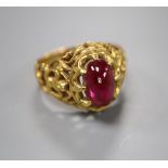 An Indian? pierced yellow metal and cabochon red stone set dress ring, size N/O, gross 8 grams.