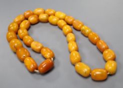 A single strand oval amber bead necklace, 74cm, gross weight 128 grams, largest bead approx. 26mm by