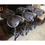 A set of six painted cast metal tractor seat stools, width 37cm depth 30cm height 64cm